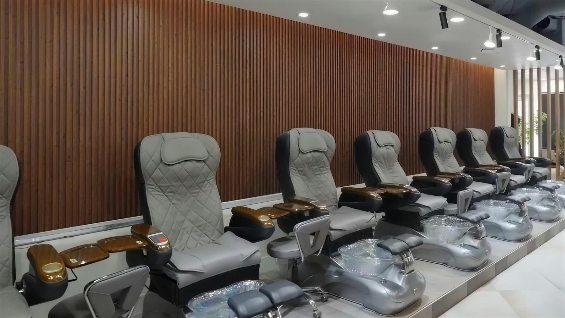 Marble manicure stations and gold lamps inside the Pedi N Nails salon